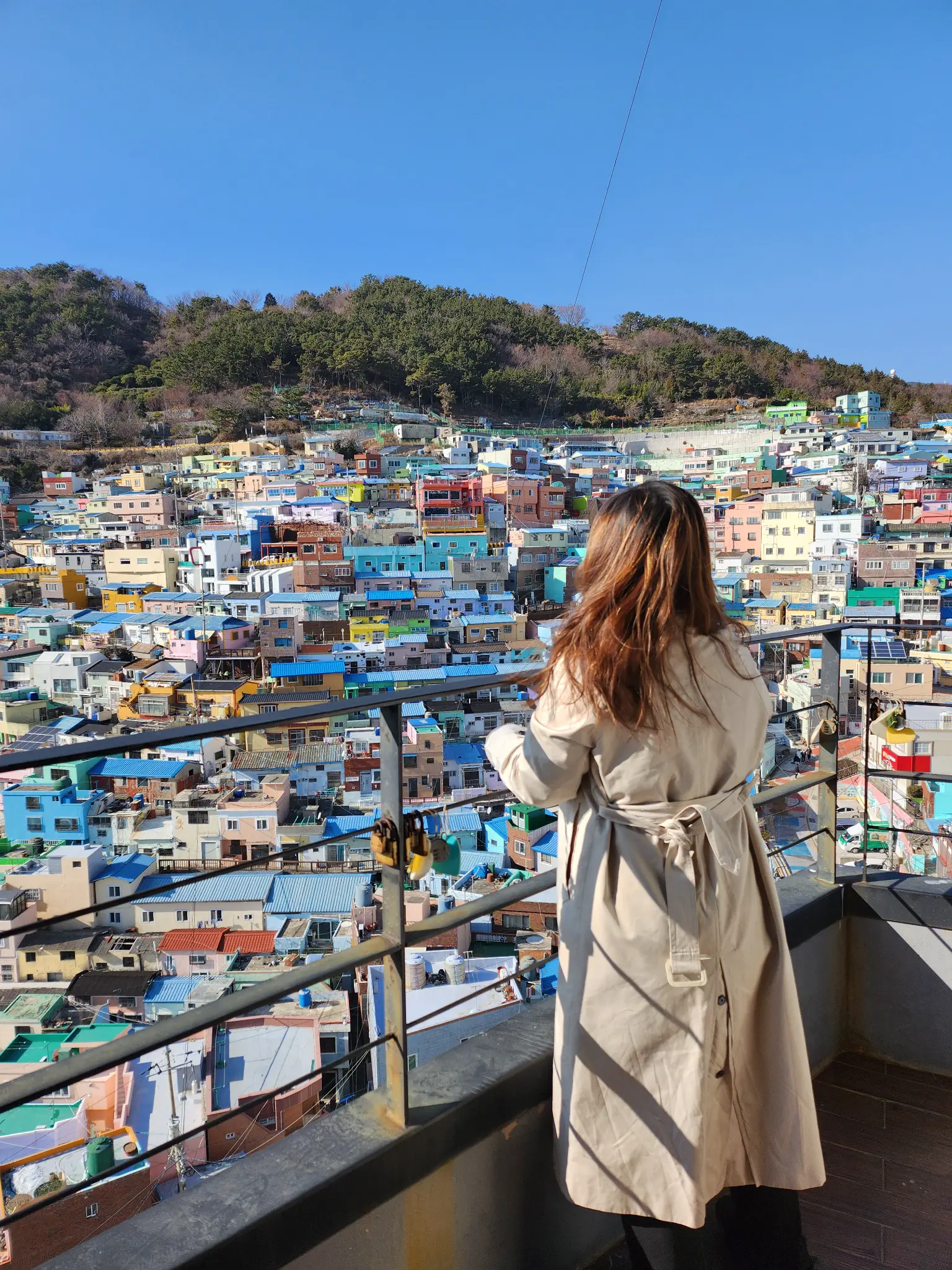 Claudia overlooking a colourful hillside neighbourhood, representing regional communications
